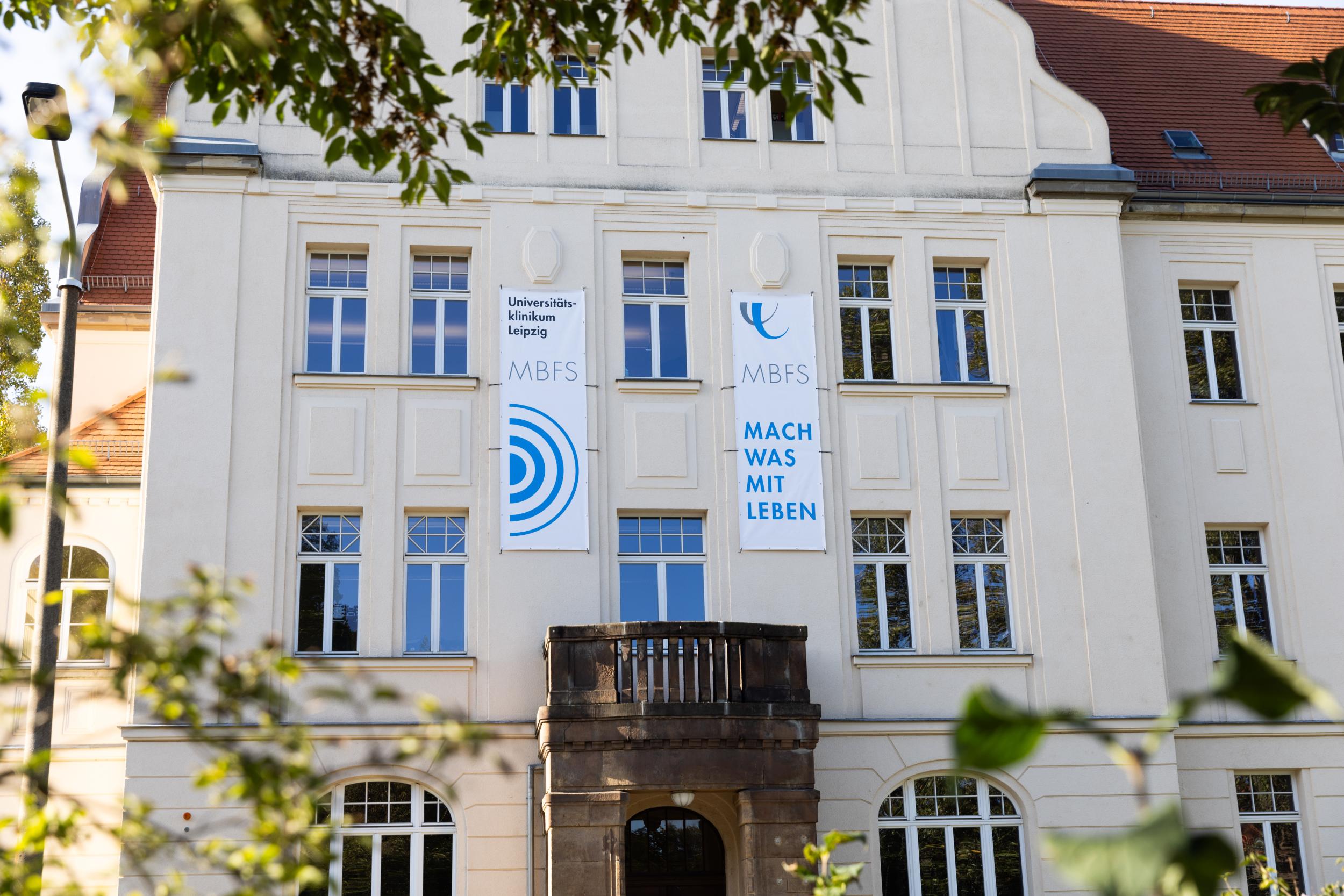 Gebäude der Medizinischen Berufsfachschule mit Bannern der Kampagne: Mach was mit Leben.